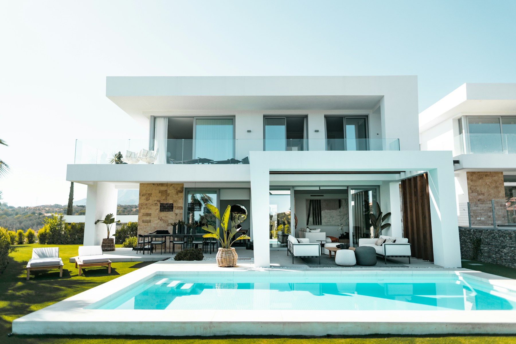 Modern luxury villa with glass balconies and a swimming pool, shown as real estate inspiration